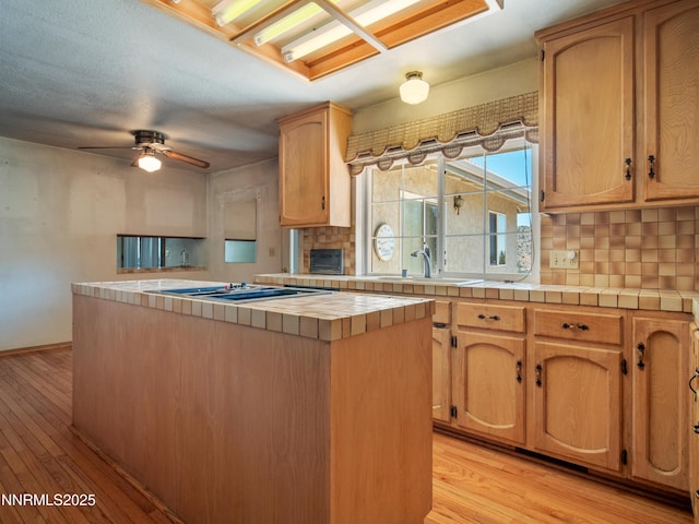 1561 Alba Vis, Gardnerville, NV 89410 - kitchen with cooktop, tile countertops, tasteful backsplash, and light wood-style floors