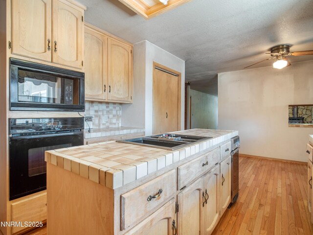 1561 Alba Vis, Gardnerville, NV 89410 - kitchen featuring black appliances, tile counters, light brown cabinets, tasteful backsplash, and light wood finished floors