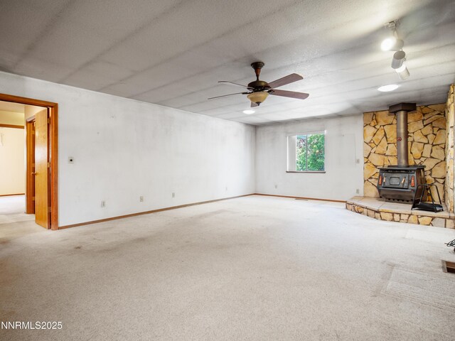 1561 Alba Vis, Gardnerville, NV 89410 - unfurnished living room with a wood stove, ceiling fan, and carpet flooring