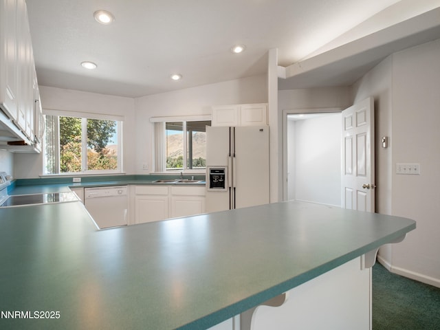 1561 Alba Vis, Gardnerville, NV 89410 - kitchen featuring white appliances, recessed lighting, a peninsula, a kitchen breakfast bar, and white cabinets