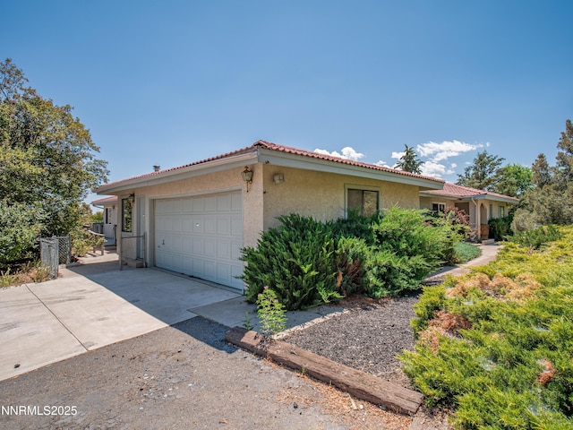 1561 Alba Vis, Gardnerville, NV 89410 - view of property exterior with stucco siding, a tiled roof, concrete driveway, an attached garage, and a gate