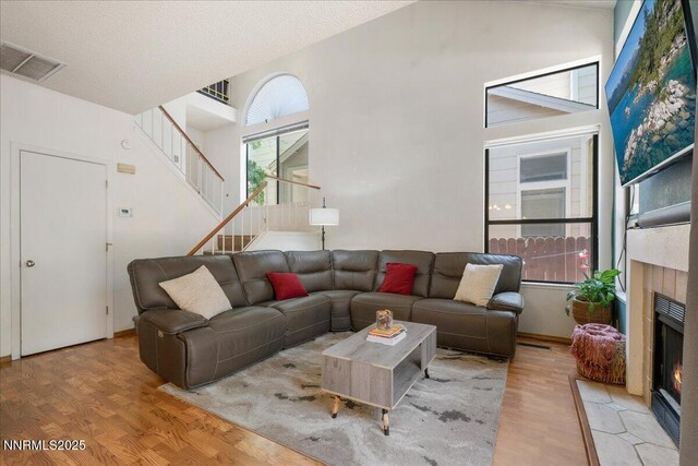 4318 Leeward Ln, Reno, NV 89502 - living area featuring stairway, wood finished floors, a fireplace with flush hearth, and high vaulted ceiling