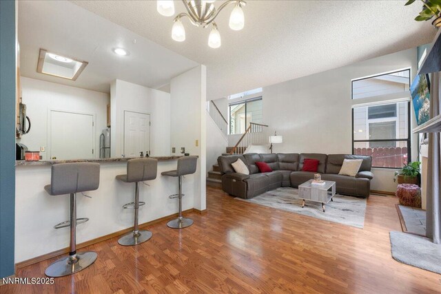 4318 Leeward Ln, Reno, NV 89502 - living room featuring wood finished floors, stairway, a chandelier, and a textured ceiling