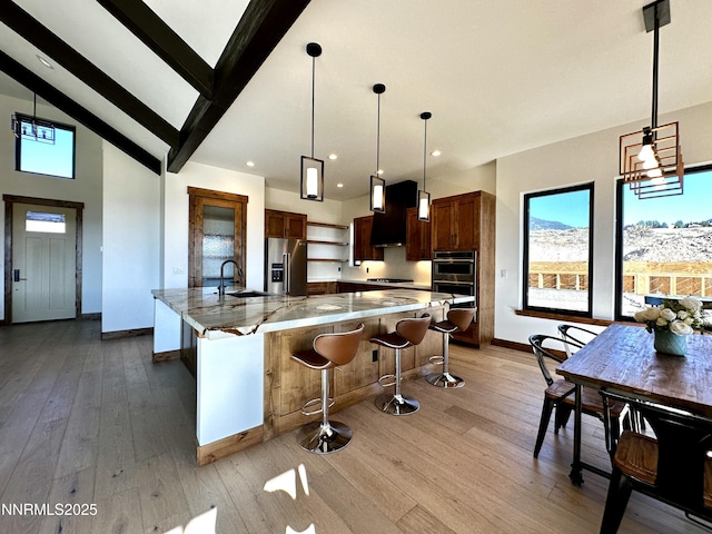 2935 Portrush Dr, Genoa, NV 89411 - kitchen featuring stainless steel appliances, light wood-style flooring, a large island, decorative light fixtures, and high vaulted ceiling