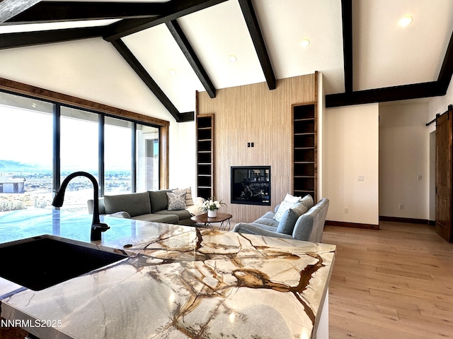 2935 Portrush Dr, Genoa, NV 89411 - living area with light wood-type flooring, built in shelves, high vaulted ceiling, beamed ceiling, and a barn door