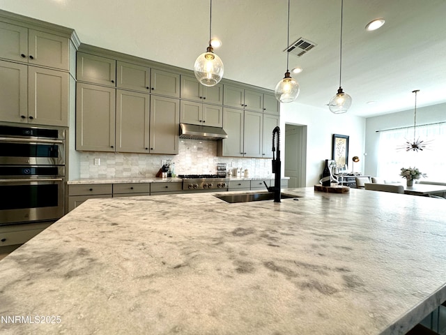 5454 Side Saddle Trl, Reno, NV 89511 - kitchen featuring appliances with stainless steel finishes, under cabinet range hood, decorative backsplash, light stone countertops, and recessed lighting