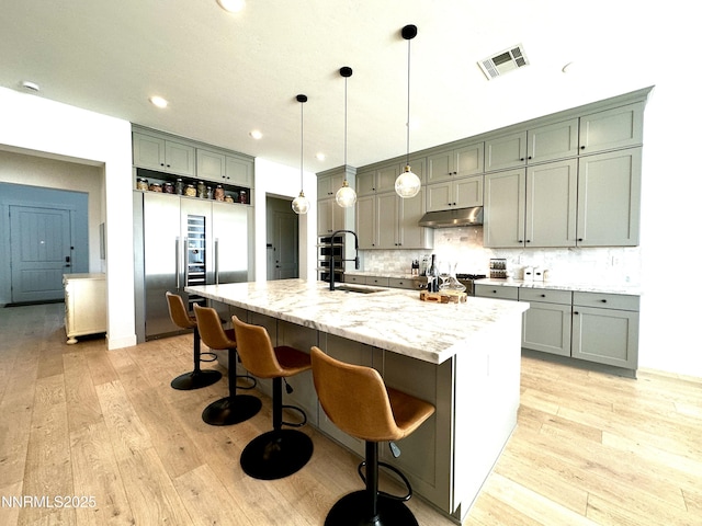 5454 Side Saddle Trl, Reno, NV 89511 - kitchen with built in fridge, under cabinet range hood, light wood finished floors, backsplash, and recessed lighting