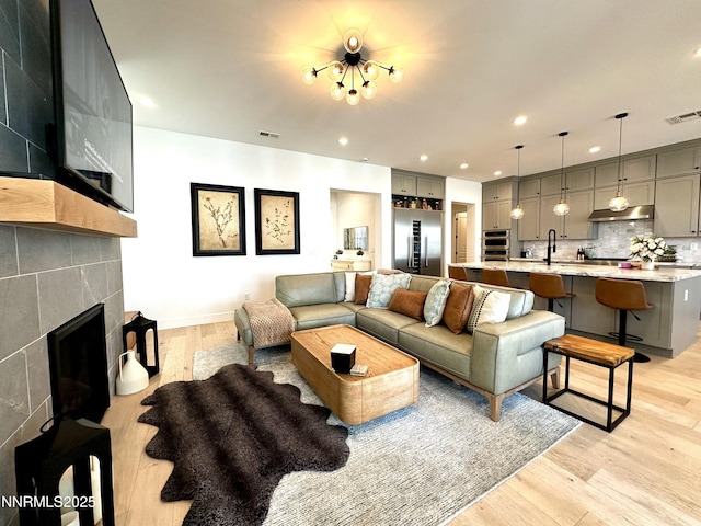 5454 Side Saddle Trl, Reno, NV 89511 - living room featuring light wood-type flooring, a tiled fireplace, and recessed lighting