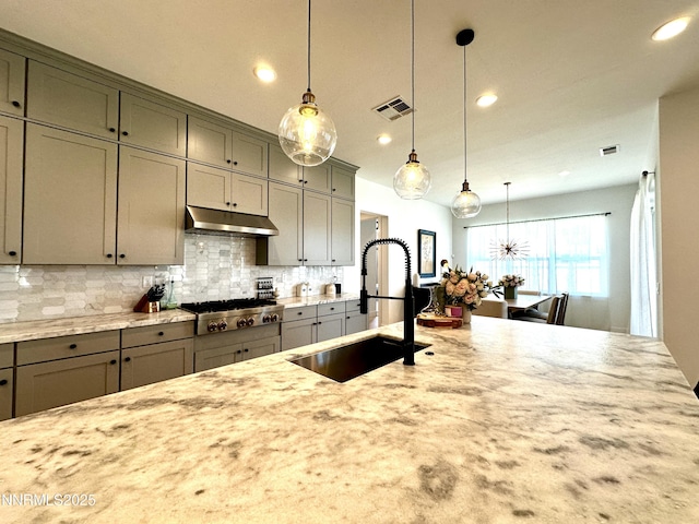 5454 Side Saddle Trl, Reno, NV 89511 - kitchen with stainless steel gas stovetop, gray cabinets, recessed lighting, light stone countertops, and decorative backsplash