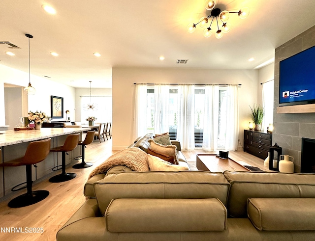 5454 Side Saddle Trl, Reno, NV 89511 - living area with light wood-type flooring, recessed lighting, a chandelier, and a tile fireplace