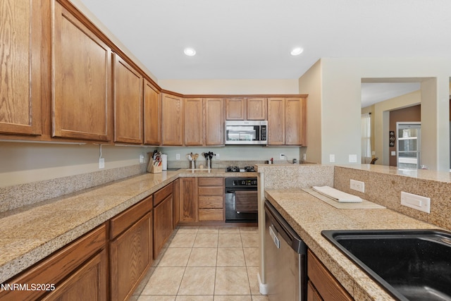 164 Oakridge Dr, Dayton, NV 89403 - kitchen featuring black appliances, light tile patterned floors, recessed lighting, and brown cabinetry