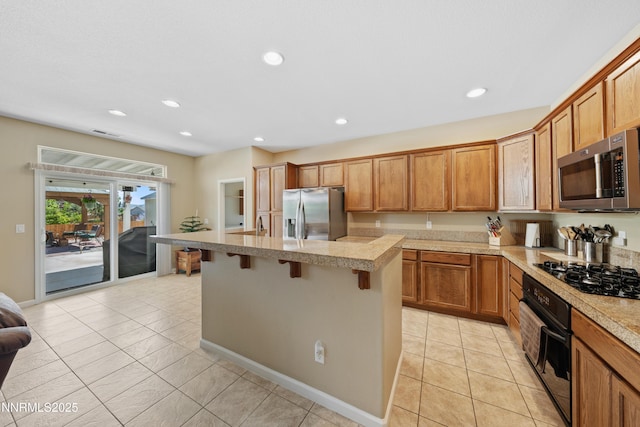 164 Oakridge Dr, Dayton, NV 89403 - kitchen featuring black appliances, a kitchen breakfast bar, light tile patterned floors, a kitchen island, and recessed lighting