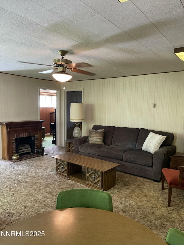 4 3rd St, Mcgill, NV 89318 - carpeted living room featuring a fireplace, a ceiling fan, and wood walls