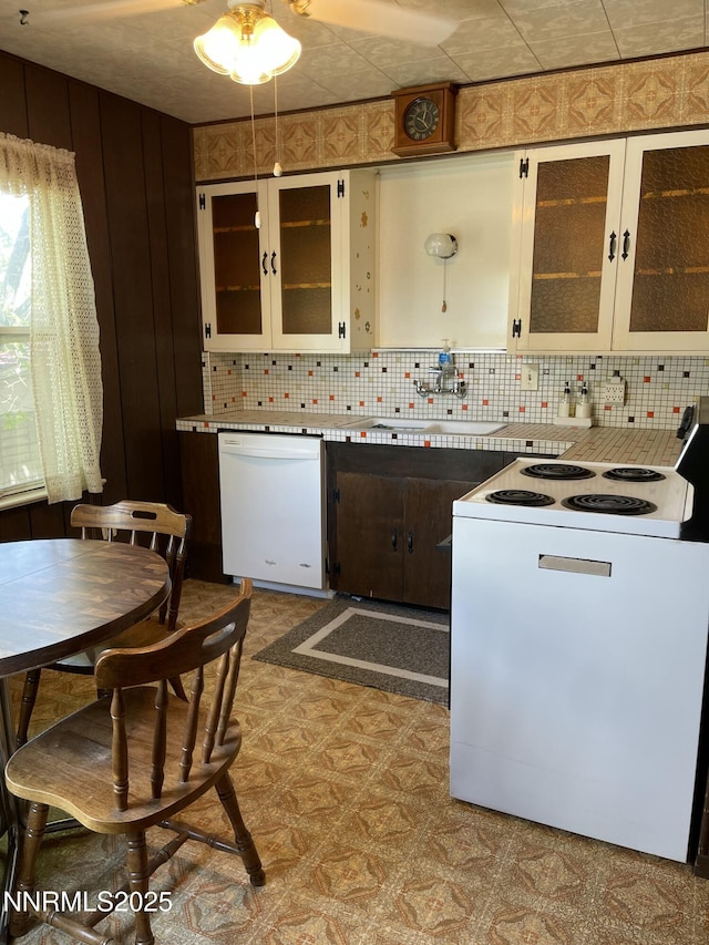 4 3rd St, Mcgill, NV 89318 - kitchen with white appliances, tasteful backsplash, tile patterned floors, and glass insert cabinets