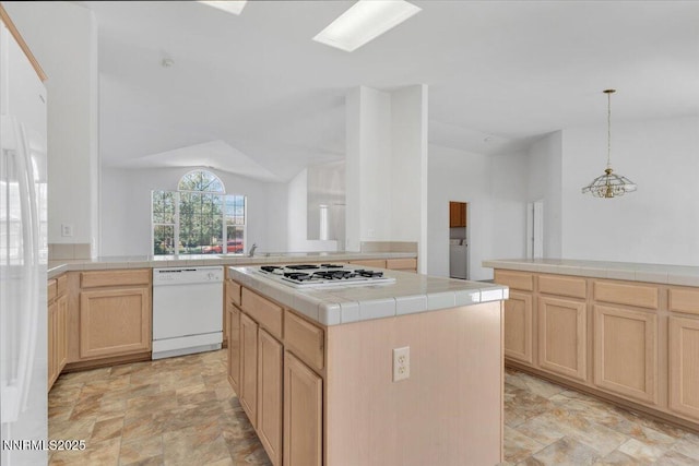 1797 Lantana Dr, Minden, NV 89423 - kitchen with white appliances, tile countertops, light brown cabinetry, stone finish floors, and vaulted ceiling