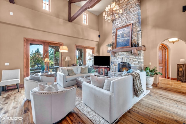 186 Carleton Ct, Reno, NV 89511 - living area featuring a towering ceiling, arched walkways, a chandelier, a fireplace, and hardwood / wood-style flooring