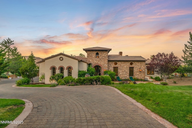 186 Carleton Ct, Reno, NV 89511 - view of front facade featuring curved driveway, a front lawn, stone siding, and stucco siding