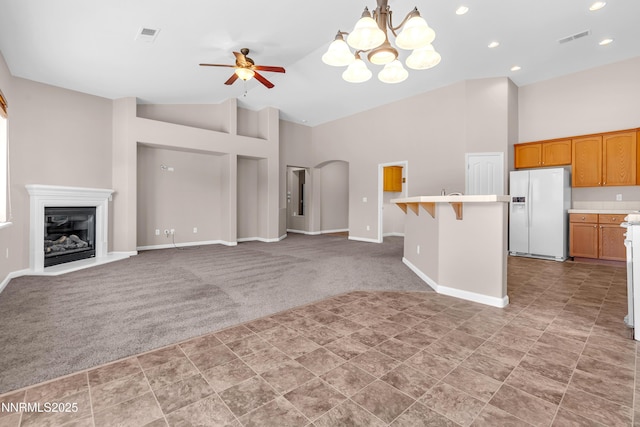 5287 Vidette Meadows Dr, Sparks, NV 89436 - unfurnished living room with light carpet, high vaulted ceiling, a chandelier, ceiling fan, and a glass covered fireplace