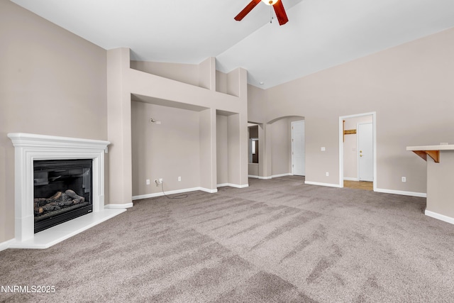 5287 Vidette Meadows Dr, Sparks, NV 89436 - unfurnished living room with a ceiling fan, carpet flooring, a glass covered fireplace, arched walkways, and high vaulted ceiling