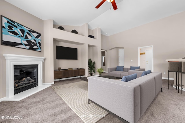 5287 Vidette Meadows Dr, Sparks, NV 89436 - carpeted living room with ceiling fan, arched walkways, a glass covered fireplace, and high vaulted ceiling