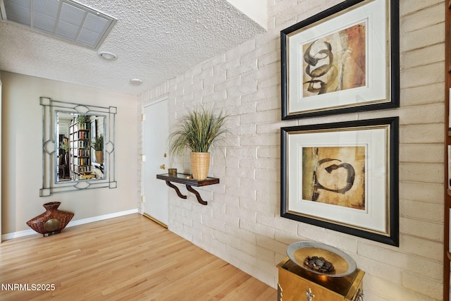 1200 Riverside Dr # 1232, Reno, NV 89503 - hallway with wood finished floors, a textured ceiling, and brick wall