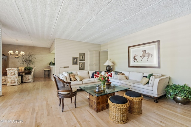 1200 Riverside Dr # 1232, Reno, NV 89503 - living room featuring wood finished floors, a chandelier, a textured ceiling, and brick wall