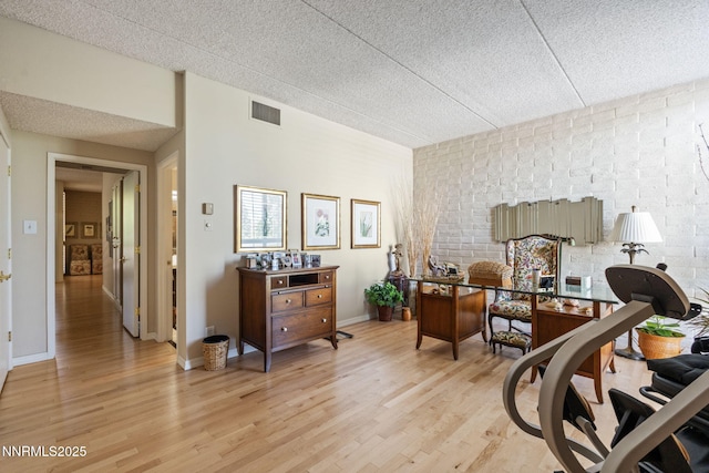 1200 Riverside Dr # 1232, Reno, NV 89503 - bedroom featuring light wood-type flooring, a textured ceiling, and brick wall