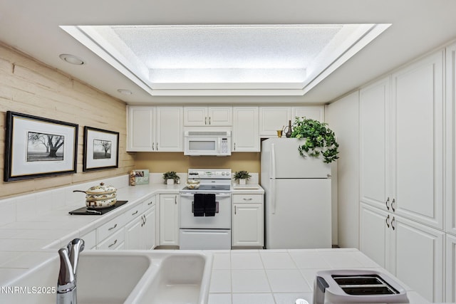 1200 Riverside Dr # 1232, Reno, NV 89503 - kitchen with white appliances, tile counters, white cabinets, and a tray ceiling