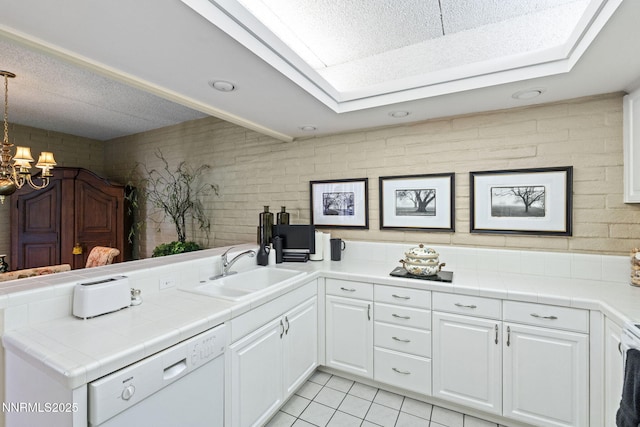 1200 Riverside Dr # 1232, Reno, NV 89503 - kitchen featuring dishwasher, a peninsula, white cabinetry, tile countertops, and light tile patterned floors