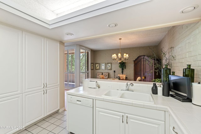 1200 Riverside Dr # 1232, Reno, NV 89503 - kitchen with white dishwasher, tile counters, white cabinetry, a peninsula, and brick wall