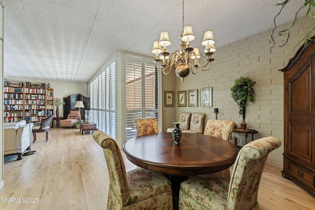 1200 Riverside Dr # 1232, Reno, NV 89503 - dining area featuring light wood finished floors, a chandelier, and a textured ceiling