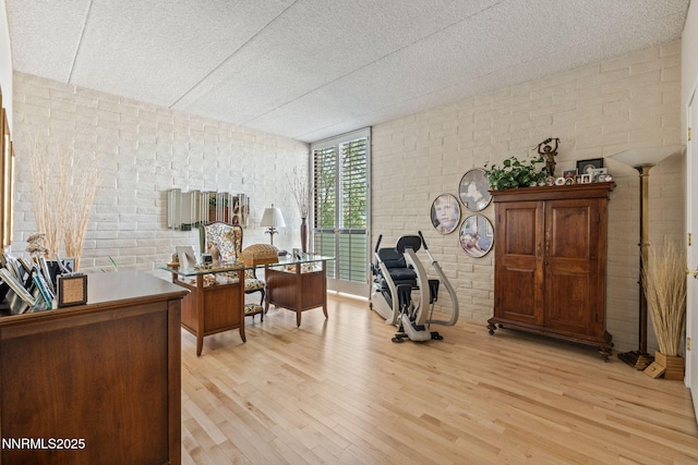 1200 Riverside Dr # 1232, Reno, NV 89503 - home office with brick wall, light wood-style flooring, and a wall of windows