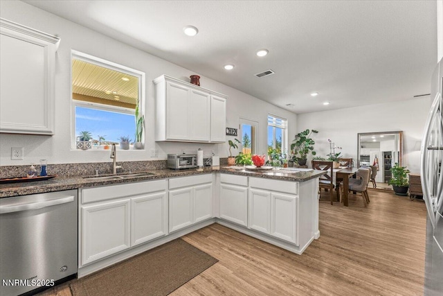 516 Beckwourth Dr, Reno, NV 89506 - kitchen featuring appliances with stainless steel finishes, white cabinetry, light wood-style flooring, a peninsula, and recessed lighting