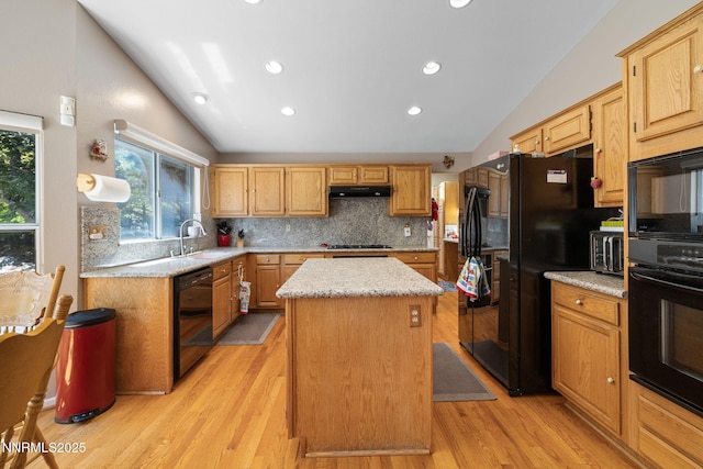 3280 Thornhill Dr, Reno, NV 89509 - kitchen with lofted ceiling, black appliances, under cabinet range hood, a kitchen island, and decorative backsplash