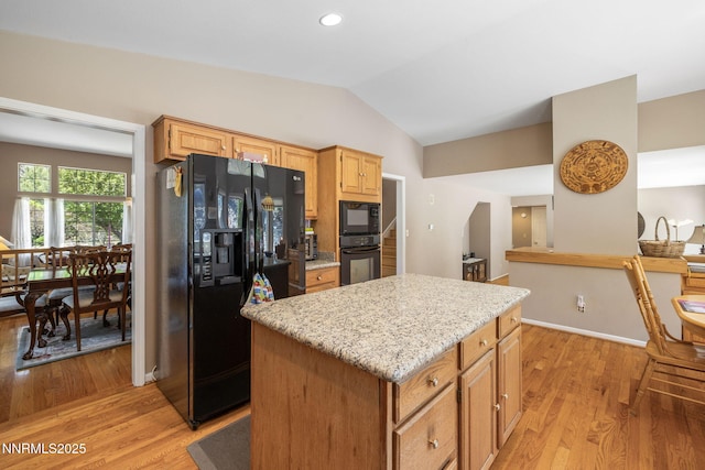 3280 Thornhill Dr, Reno, NV 89509 - kitchen with black appliances, light wood-style floors, vaulted ceiling, a center island, and light stone counters