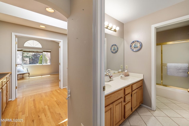 3280 Thornhill Dr, Reno, NV 89509 - bathroom featuring double vanity, bath / shower combo with glass door, and wood finished floors