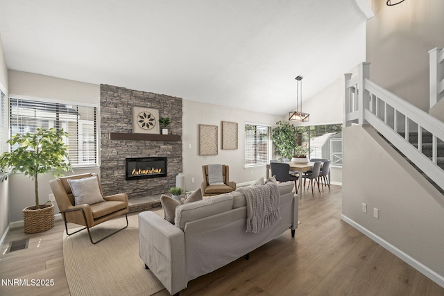4030 Willowsprings Dr, Reno, NV 89519 - living room with wood finished floors, stairs, a stone fireplace, and lofted ceiling