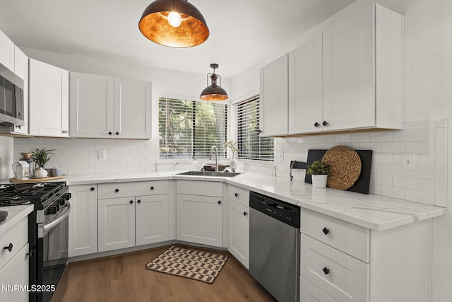 4030 Willowsprings Dr, Reno, NV 89519 - kitchen with appliances with stainless steel finishes, wood finished floors, white cabinets, tasteful backsplash, and pendant lighting