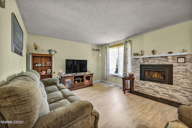 6670 Lotus St, Reno, NV 89506 - living area featuring wood finished floors, a textured ceiling, and a stone fireplace