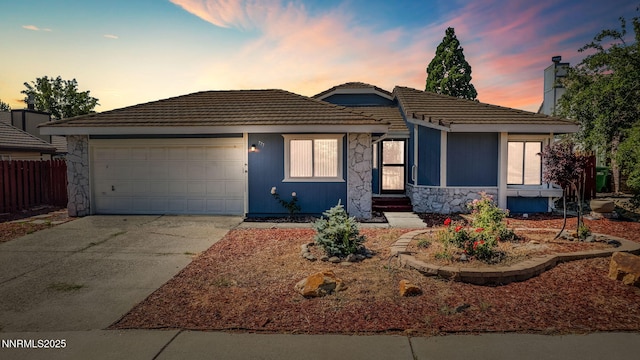 777 W Bonanza Dr, Carson City, NV 89706 - view of front of property featuring stone siding, concrete driveway, a garage, and a tile roof