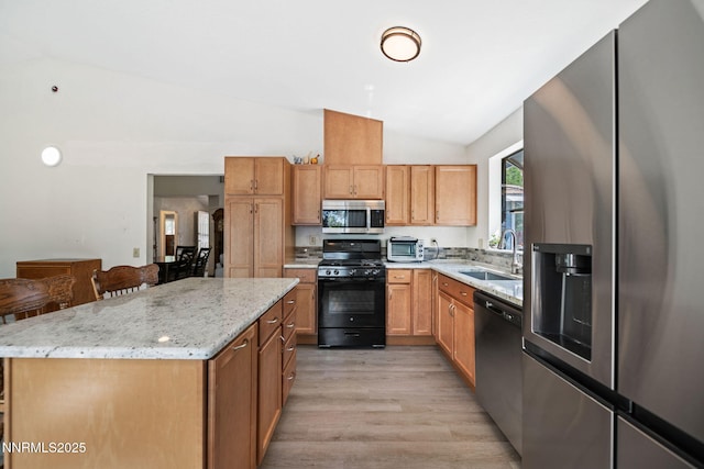777 W Bonanza Dr, Carson City, NV 89706 - kitchen featuring stainless steel appliances, lofted ceiling, light wood finished floors, light stone countertops, and a center island