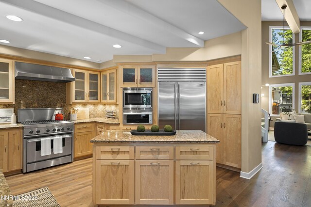 210 Allen Way, Incline Village, NV 89451 - kitchen featuring built in appliances, wall chimney exhaust hood, light brown cabinetry, tasteful backsplash, and light wood-type flooring