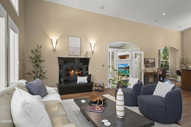 210 Allen Way, Incline Village, NV 89451 - living room featuring arched walkways, wood finished floors, a glass covered fireplace, and a towering ceiling
