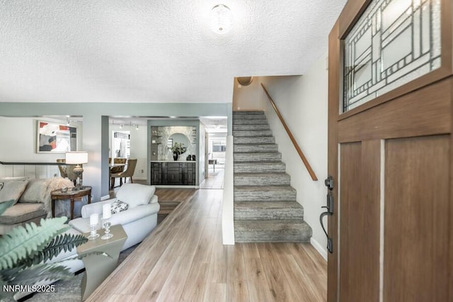 1419 Foster Dr, Reno, NV 89509 - foyer with stairs, a textured ceiling, and light wood-style flooring