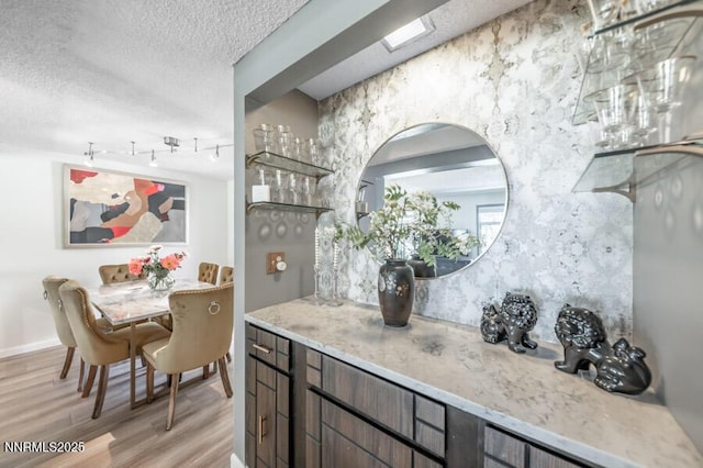 1419 Foster Dr, Reno, NV 89509 - bar area with light wood-style flooring, a textured ceiling, and rail lighting