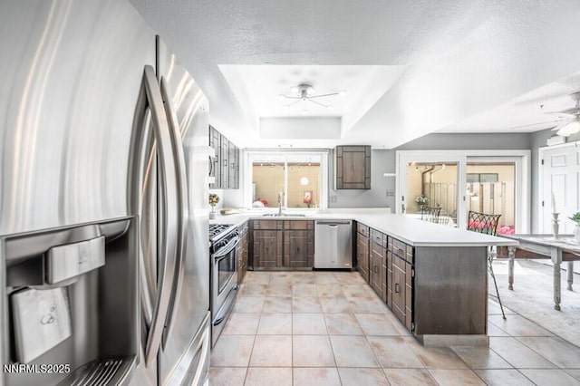 1419 Foster Dr, Reno, NV 89509 - kitchen with stainless steel appliances, a ceiling fan, a peninsula, light countertops, and a breakfast bar