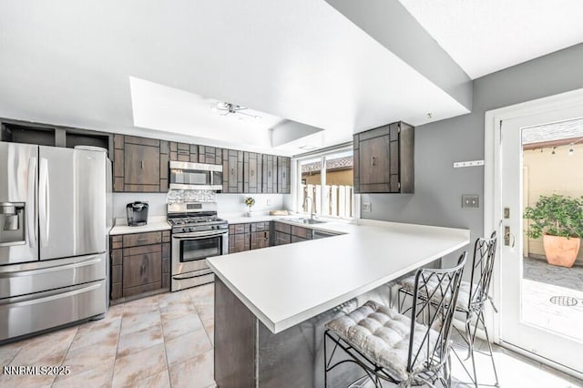 1419 Foster Dr, Reno, NV 89509 - kitchen featuring stainless steel appliances, a kitchen breakfast bar, a peninsula, light countertops, and a ceiling fan