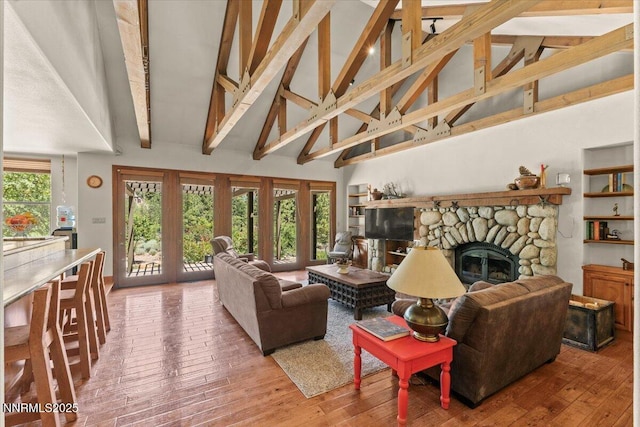 6195 Philoree Ln, Reno, NV 89511 - living area featuring high vaulted ceiling, a stone fireplace, hardwood / wood-style floors, and beam ceiling