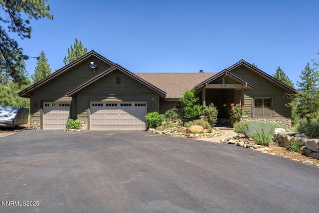 6195 Philoree Ln, Reno, NV 89511 - view of front of house featuring stone siding, a garage, and asphalt driveway