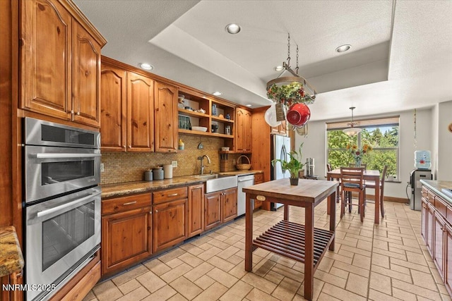 6195 Philoree Ln, Reno, NV 89511 - kitchen with stainless steel appliances, brown cabinetry, open shelves, decorative backsplash, and recessed lighting